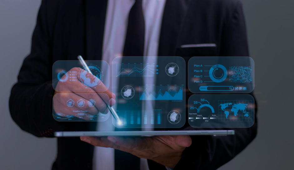Business professional in a suit interacts with a tablet, displaying digital blue graphs and charts, symbolizing data analysis and technology.