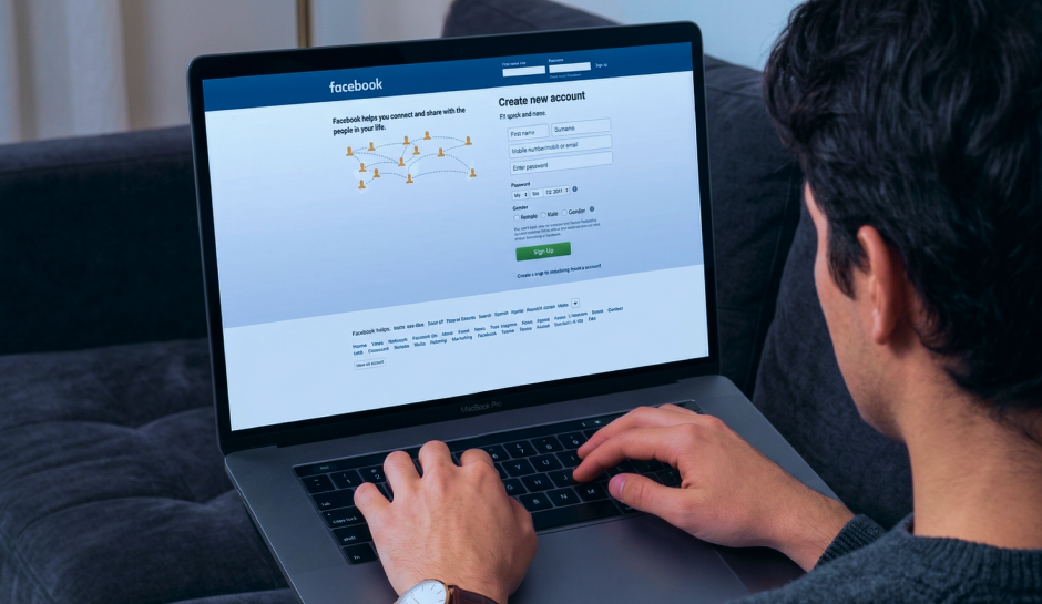 Person using a laptop to access Facebook's sign-up page, preparing to create a new account by entering personal details.