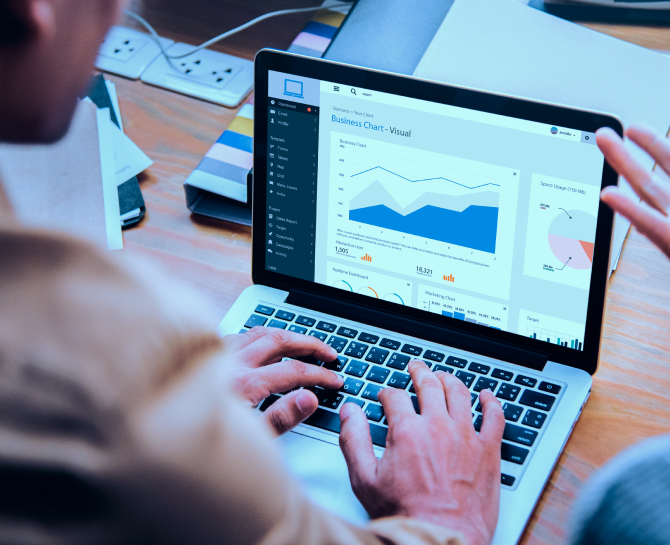 Person analyzing a business dashboard with charts and graphs on a laptop, displaying visual data and statistics.